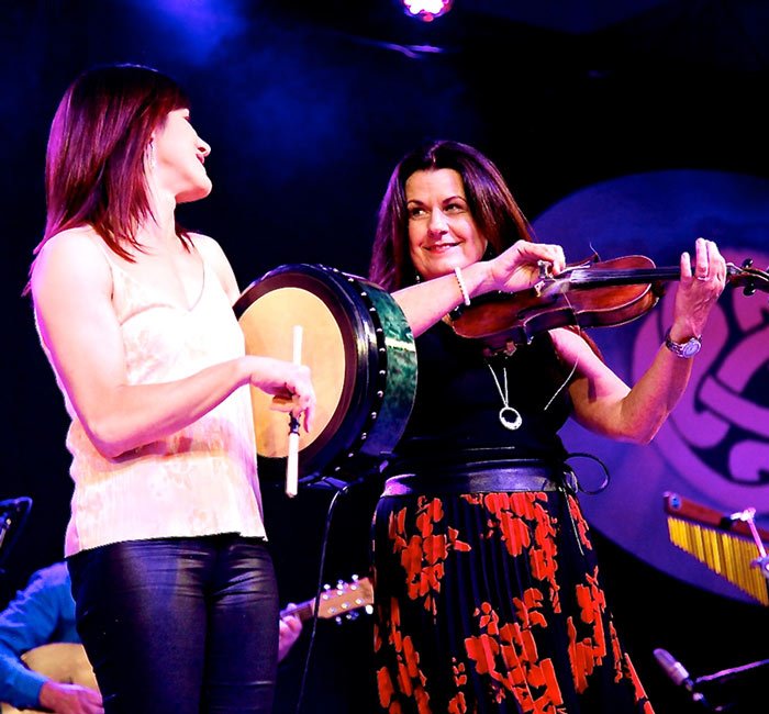 Yvonne Fahy and Máirín Fahy sharing a smile mid performance.