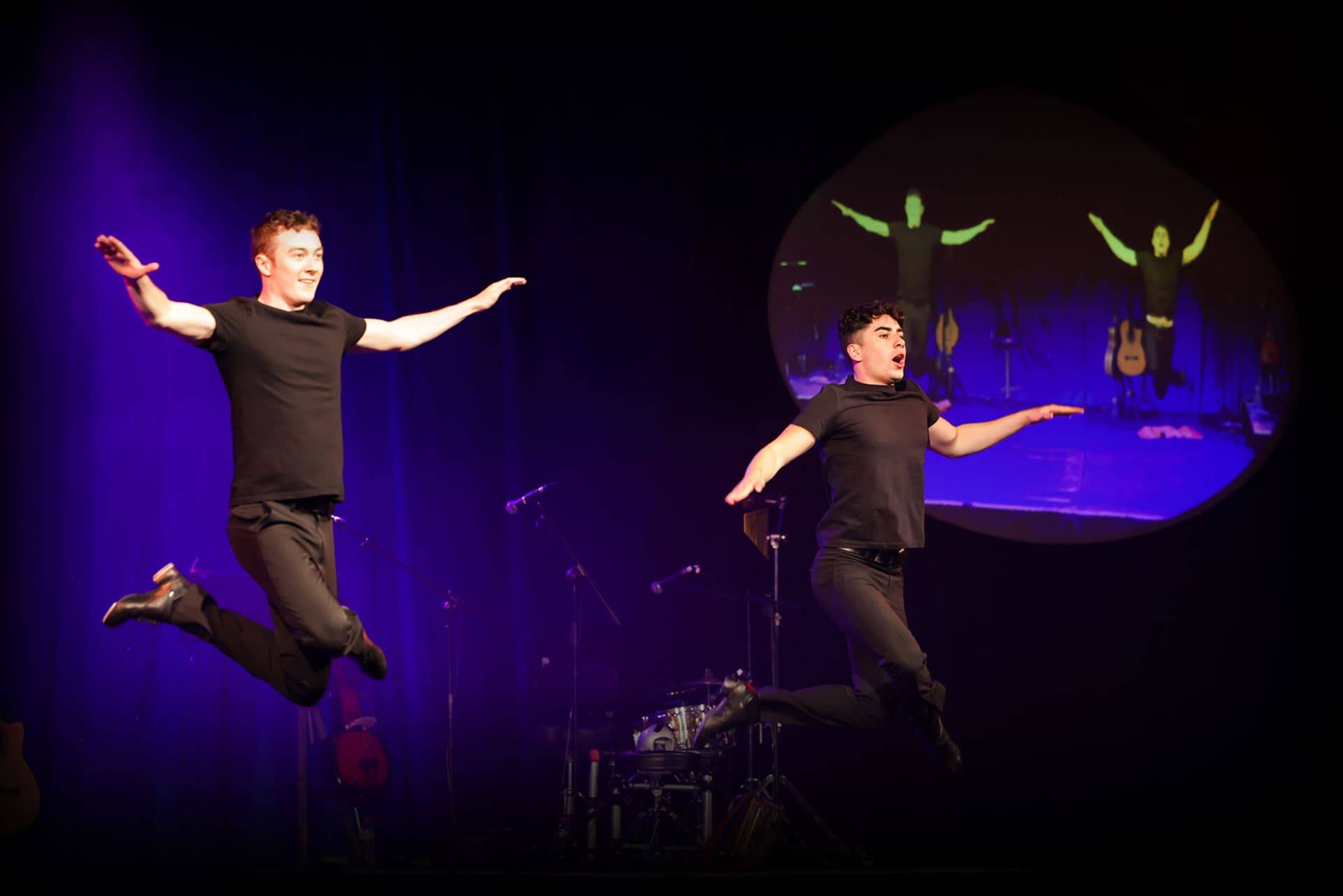Two male dancers in mid-leap