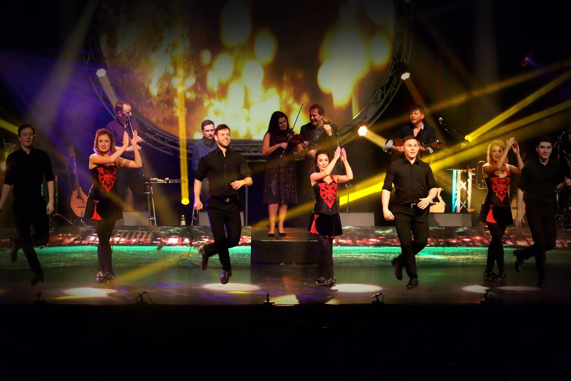 Wide shot of stage with line of male and female dancers